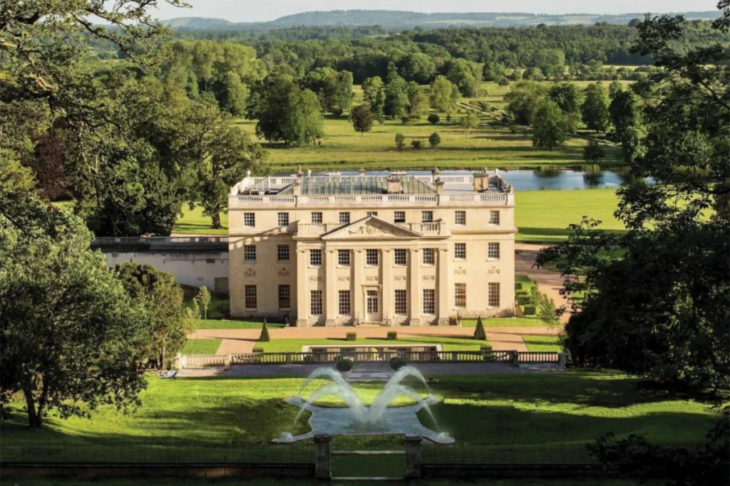 Benham Park, a Georgian country house set in rolling Berkshire parkland, with formal gardens, a fountain and a lake beyond