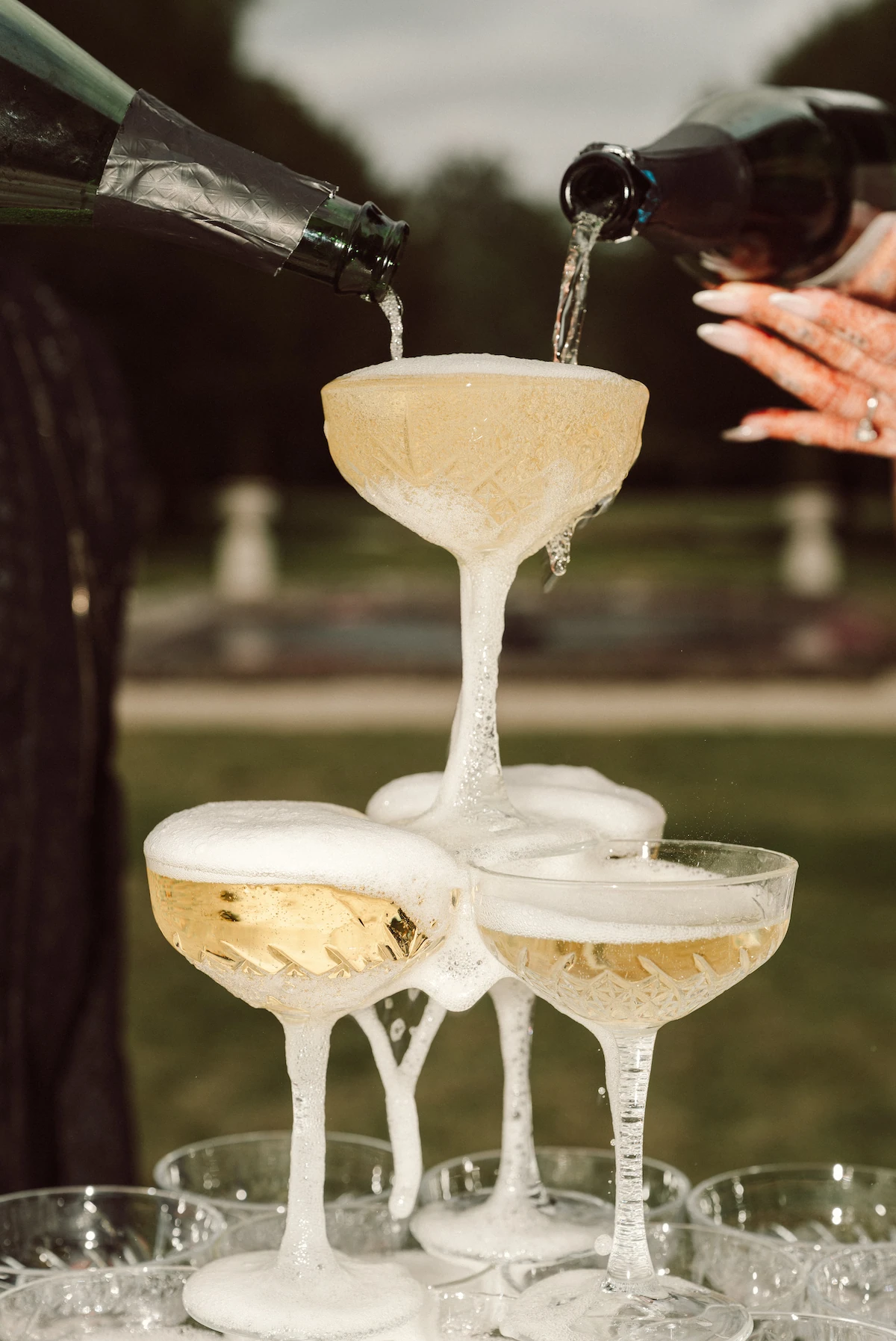Champagne being poured into a coupe glass tower