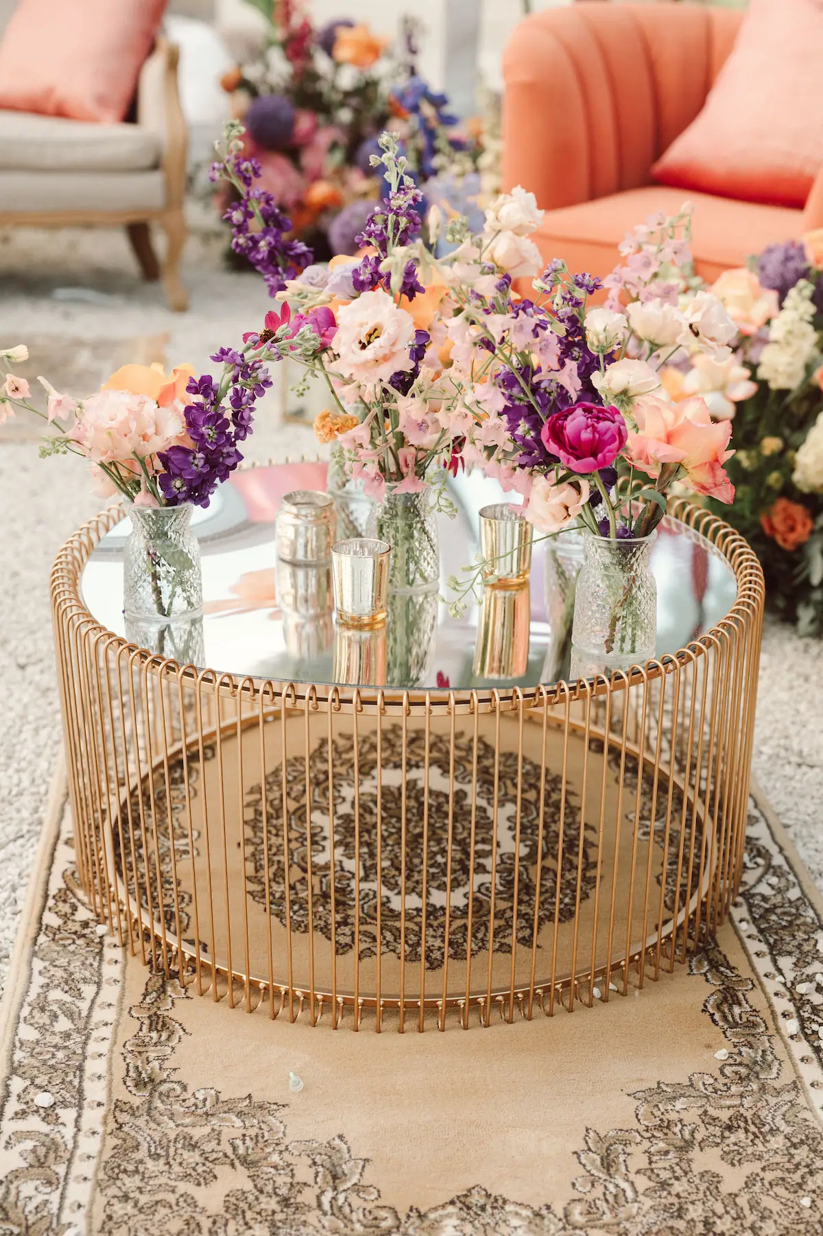 Glassware and flowers arranged on a gold mirrored table