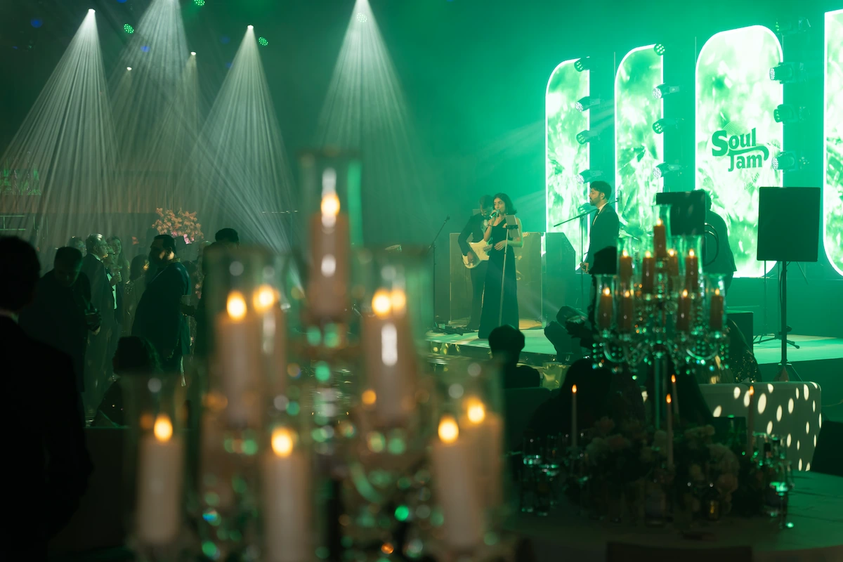 A candlelit event space bathed in green light