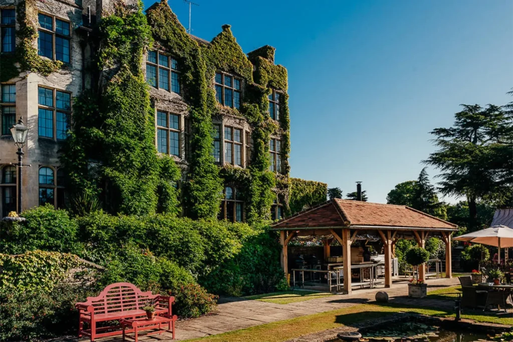 The ivy-clad manor house and terrace at Pennyhill Park, a country house hotel and event venue in Surrey
